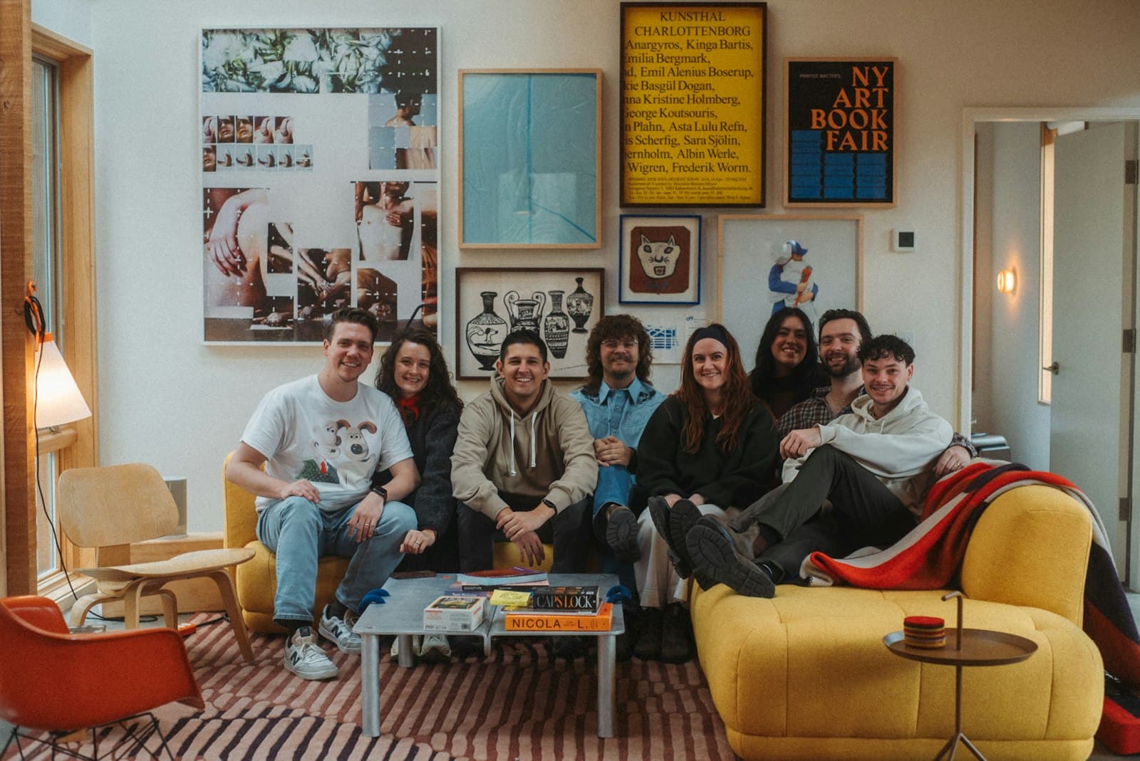 Huisgenoten samen op de bank in een woonkamer vol posters